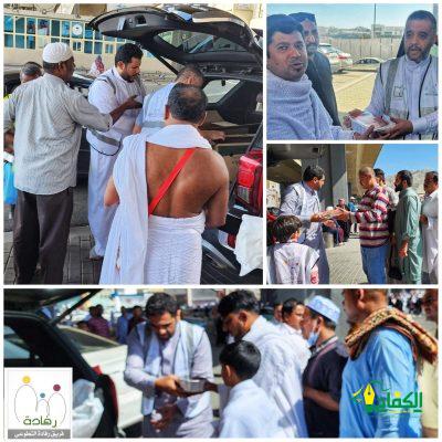 أعضاء فريق رفادة التطوعي يقومون بتوزيع وجبات ساخنة للمعتمرين بجوار المسجد الحرام